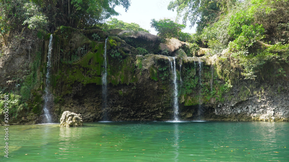 Fototapeta premium Waterfall in green rainforest. Bolinao waterfall in the mountain jungle. Philippines, Luzon. Travel concept.