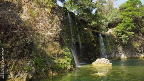 Waterfall in green rainforest. Bolinao waterfall in the mountain jungle. Philippines, Luzon. Travel concept. photo