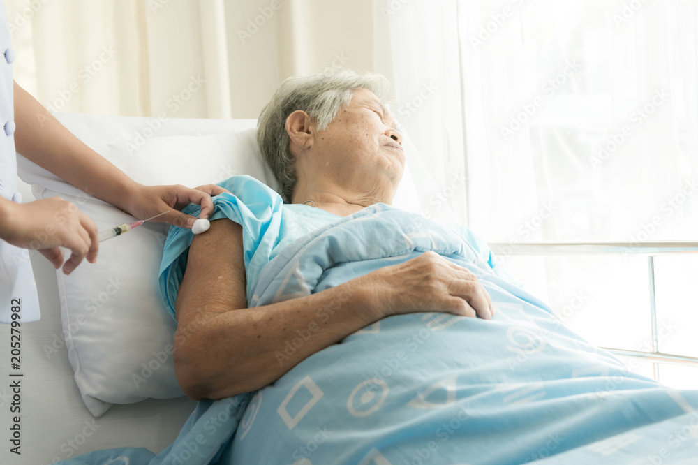 Obraz premium Nurse with patient. Routine health check and doing medical injection. Female nurse with senior chinese woman.