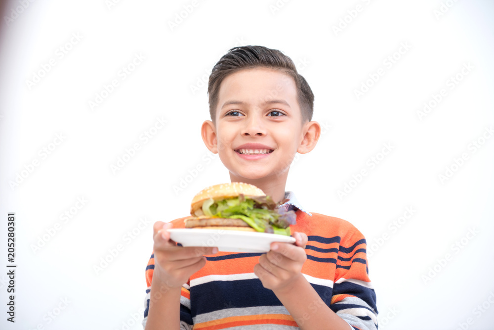 Young boy with burger isolated in white. Handsome early teenage boy portrait. Holding a burger. Happy smile face. Young boy with burger isolated in white. Handsome early teenage boy portrait. Holding a burger. Happy smile face.
