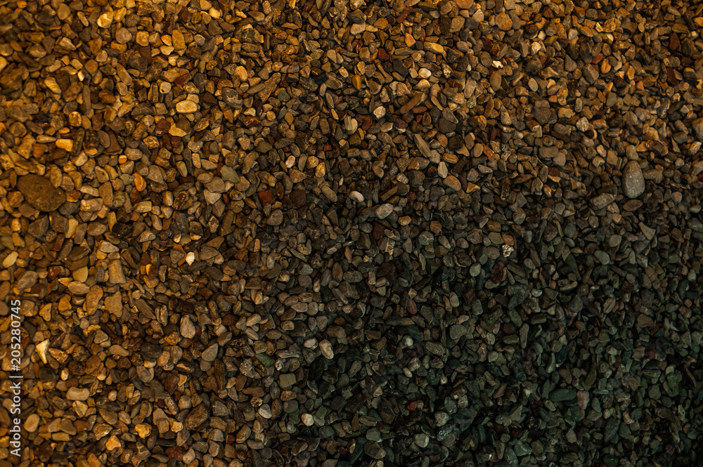 The bottom of the pond is covered with small pebbles. Playful colors of stones The bottom of the pond is covered with small pebbles. Playful colors of stones