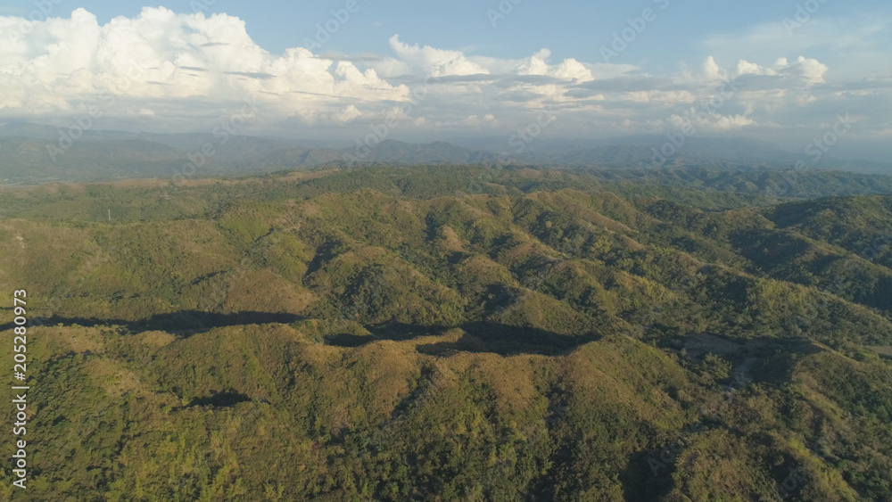 Fototapeta premium Aerial view of mountains covered forest, trees. Tropical landscape: mountains, sky with clouds. on the island of Luzon, Philippines. Mountain province, Cordillera region.