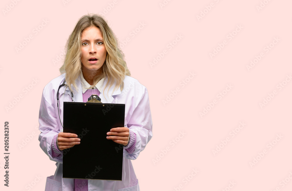 Fototapeta premium Young doctor woman, medical professional scared in shock, expressing panic and fear