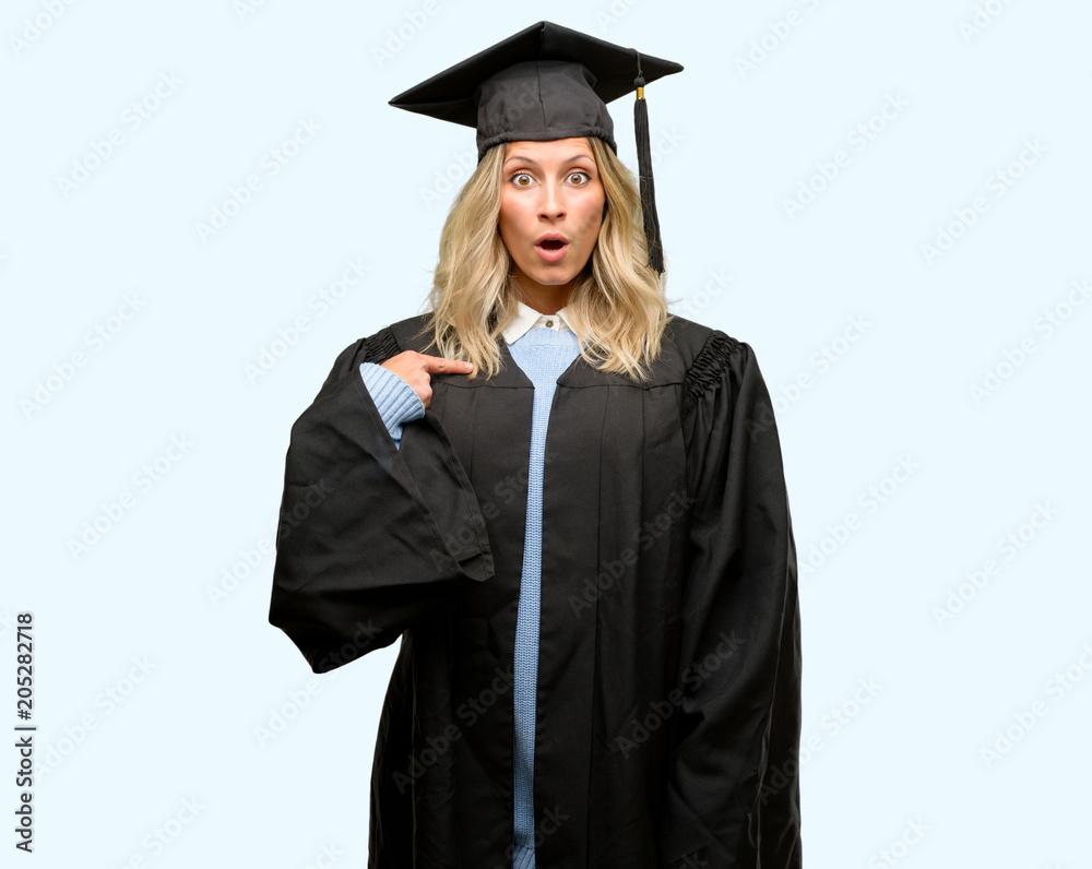 Young graduate woman happy and surprised cheering expressing wow gesture, pointing with finger Young graduate woman happy and surprised cheering expressing wow gesture, pointing with finger