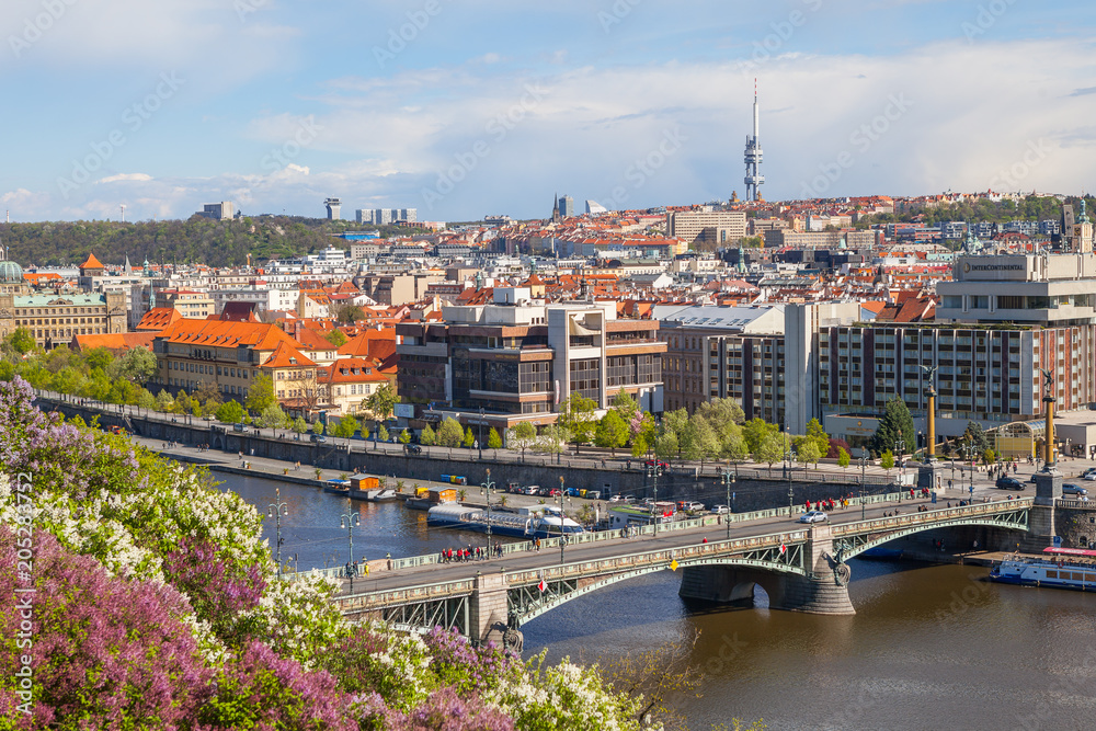 Obraz premium PRAGUE, CZECH REPUBLIC - APRIL, 30, 2017: Spring city panoramic view from Letenske garedn. Old and modern buildings and bridges over Vltava river.