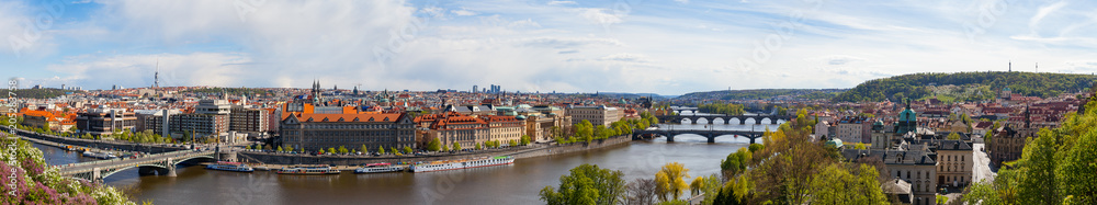 PRAGUE, CZECH REPUBLIC - APRIL, 30, 2017: Spring city ultra wide panoramic view from Letenske garedn. Old and modern buildings and bridges over Vltava river.
