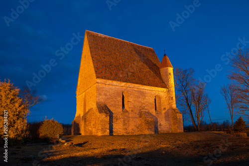 Ancient chapel on the cemetery. Night illuminated view. Saha, Estonia.