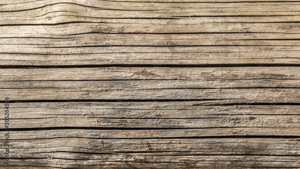the texture of old dry weathered cracked wood, cracks along the fibers of logs, close-up abstract background the texture of old dry weathered cracked wood, cracks along the fibers of logs, close-up abstract background