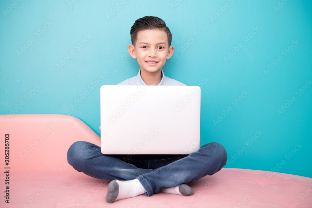 Young software programmer isolated in blue. Handsome early teenage boy portrait. Playing with notebook. Technology concept. Young software programmer isolated in blue. Handsome early teenage boy portrait. Playing with notebook. Technology concept.