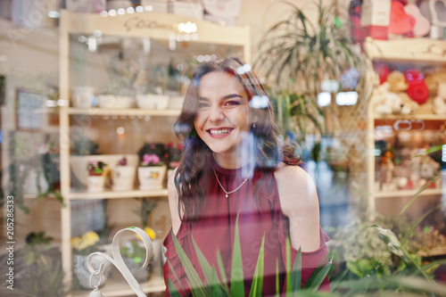 Brunette girl in red buy flowers at flower store.