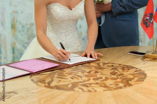The Bride puts her signature in the marriage document.