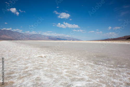 Badwater in den Badlands der USA , eine weite weisse Salzebene mit intensiv blauem Himmel