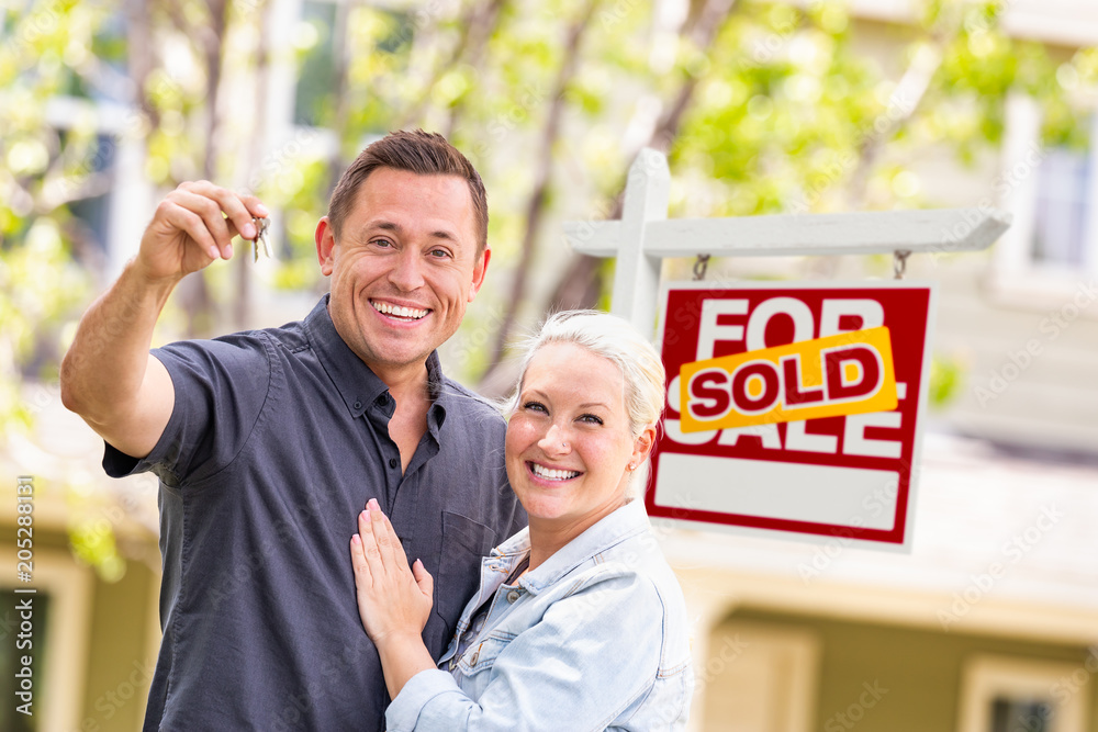 Caucasian Couple in Front of Sold Real Estate Sign and House with Keys ...