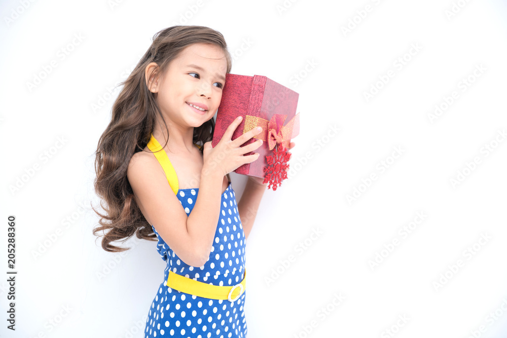 Young girl got suprise gift. Young cute white girl holding a red gift present box, looking funny and surprise. Isolated in white. Birthday girl and family concept. Young girl got suprise gift. Young cute white girl holding a red gift present box, looking funny and surprise. Isolated in white. Birthday girl and family concept.