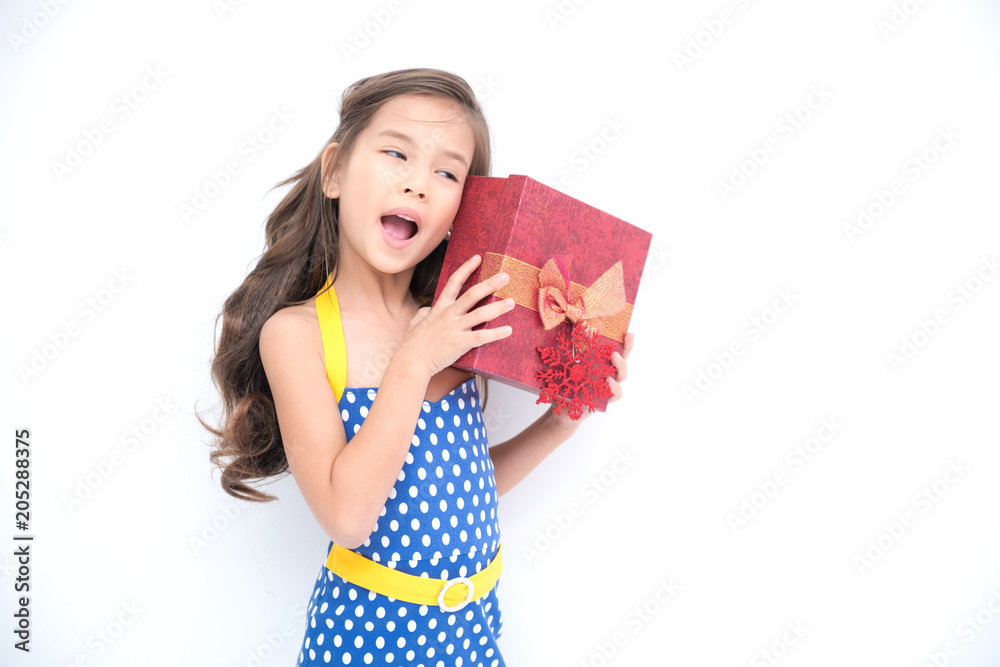 Young girl got suprise gift. Young cute white girl holding a red gift present box, looking funny and surprise. Isolated in white. Birthday girl and family concept. Young girl got suprise gift. Young cute white girl holding a red gift present box, looking funny and surprise. Isolated in white. Birthday girl and family concept.