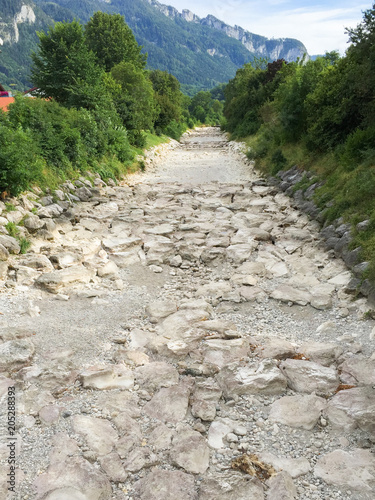 Ein ausgetrocknetes, schnurgerades Flußbett der Prien in Bayern. Wasser wird knapp
