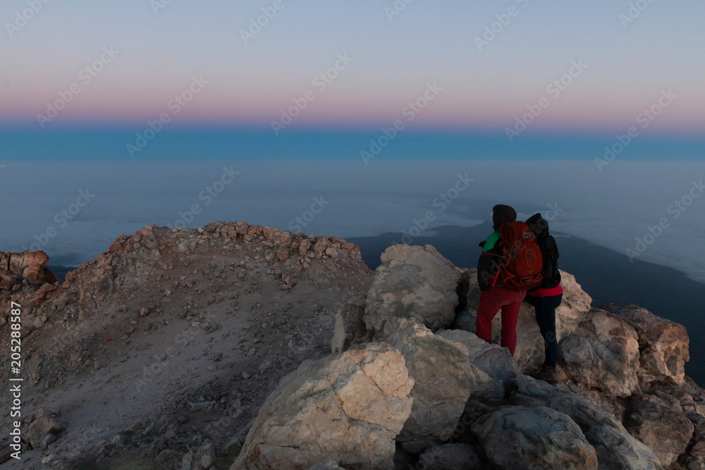 A couple watching the sunrise at the summit of Pico del Teide, Tenerife