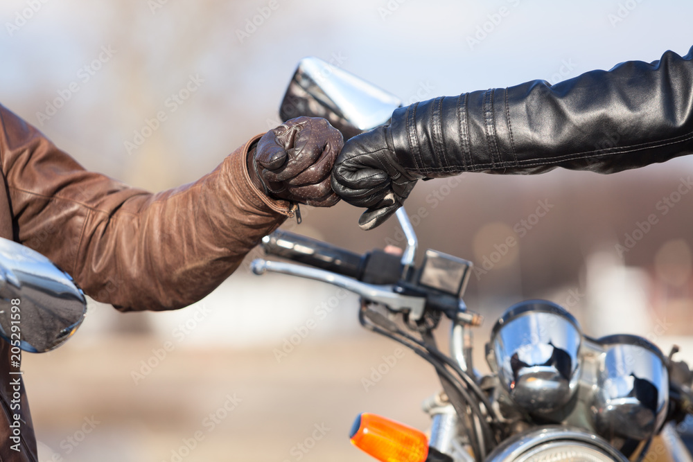 Naklejka premium Zbliżenie dłoni rowerzystów w skórzane rękawiczki z pozdrowieniem spłaty