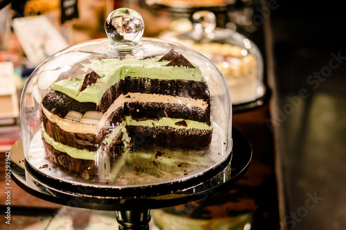 Chocolate mint layer cake under glass bell dome. Cake stand, dessert buffet, storage