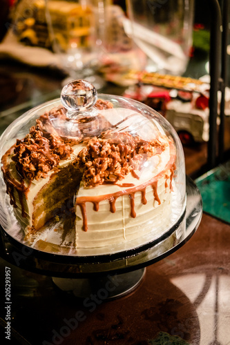 Caramel cake under glass bell dome. Cake stand, dessert buffet, storage
