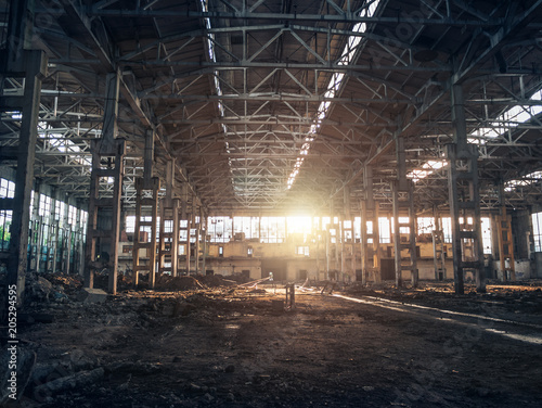 Ruined and abandoned dark creepy factory house building inside, industrial warehouse hall waiting for demolition