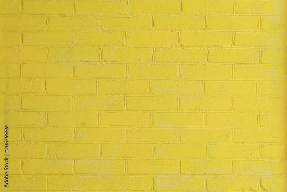 Obraz premium Yellow painted brick wall as a background or backdrop