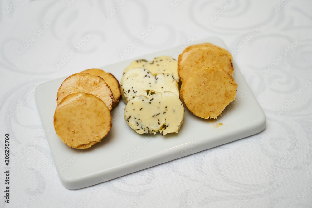 Butter flavored with herbs and spices on ceramic cutting board, close-up. Butter flavored with herbs and spices on ceramic cutting board, close-up.