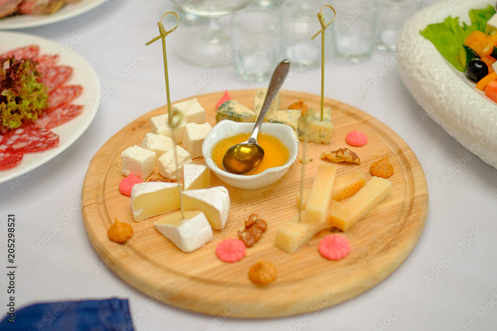 Cheese plate served with white wine, crackers and nuts, Top view. Assorted cheeses Camembert, Brie, Parmesan blue cheese Cheese plate served with white wine, crackers and nuts, Top view. Assorted cheeses Camembert, Brie, Parmesan blue cheese