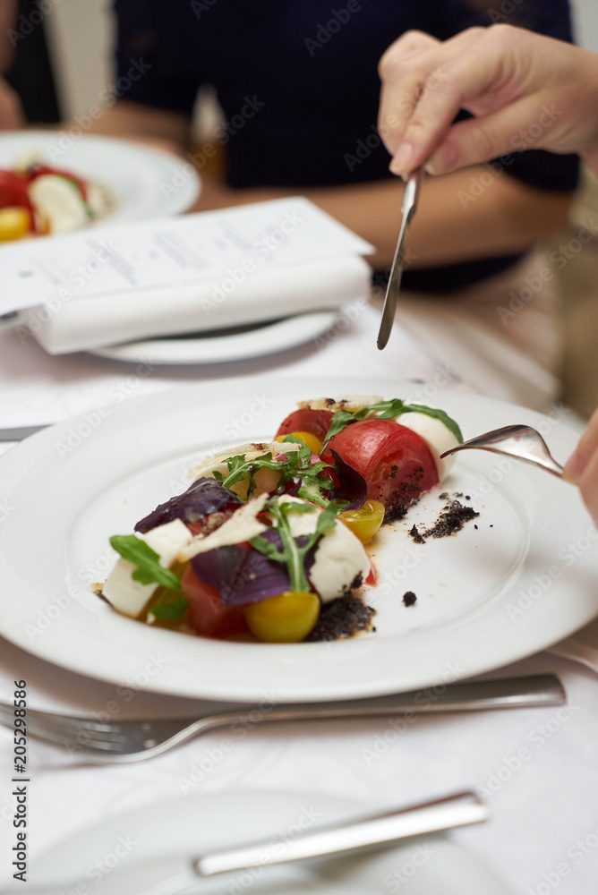 Vegetarian food with marinated tomatoes, arugula, mozzarella cheese, balsamic jelly, olive oil. Delicious healthy food concept, close-up Vegetarian food with marinated tomatoes, arugula, mozzarella cheese, balsamic jelly, olive oil. Delicious healthy food concept, close-up