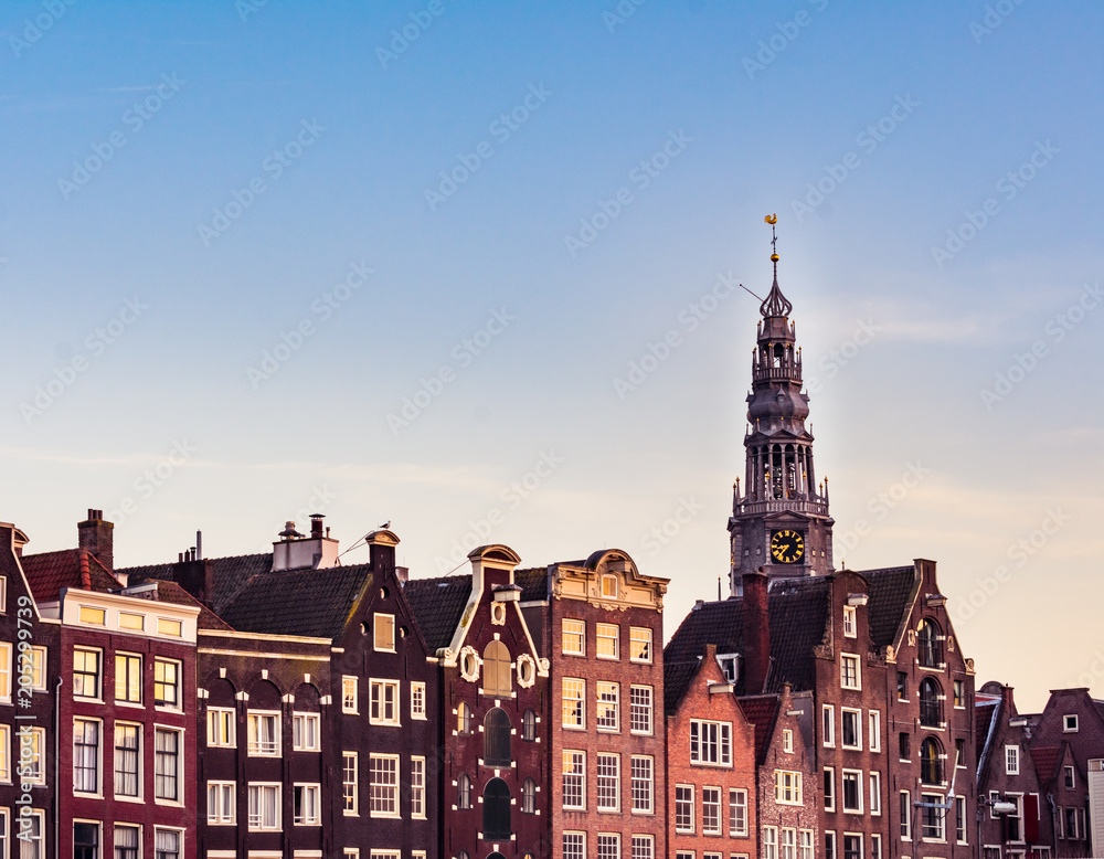 Fototapeta premium View of colorful Amsterdam houses and the tower of Westerkerk church during sunset