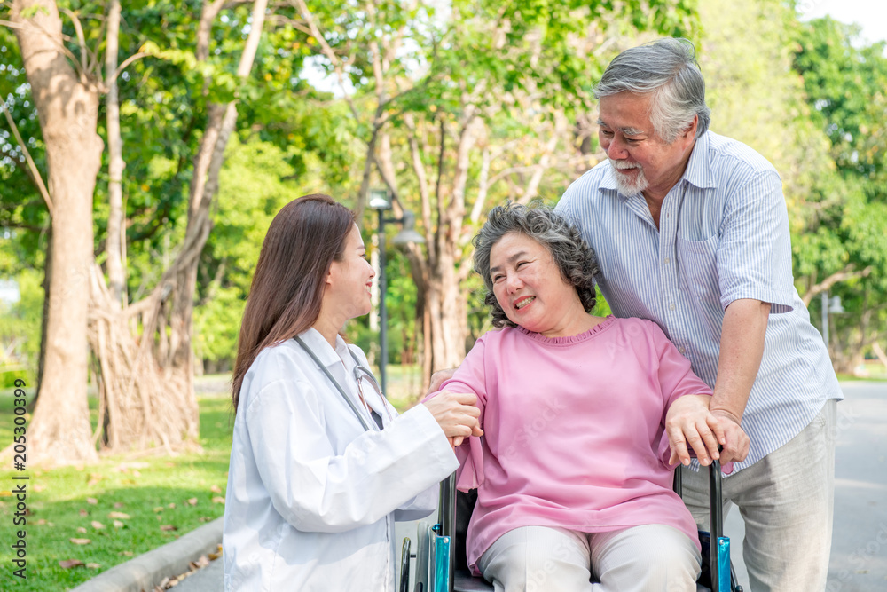 Nurse with senior patient in park. Senior disable woman in wheelchair relaxing and being comfort by a chinese female nurse. Nurse with senior patient in park. Senior disable woman in wheelchair relaxing and being comfort by a chinese female nurse.