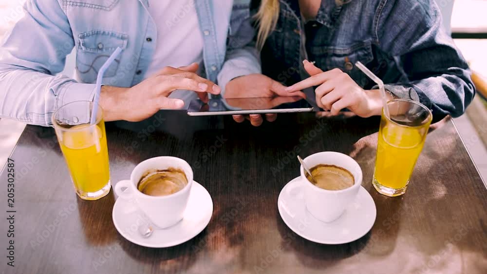 Couple using tablet while sitting at cafe - close up
Couple using tablet while sitting at cafe - close up