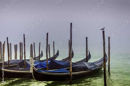 Gondolas in Venice at twilight in a foggy day