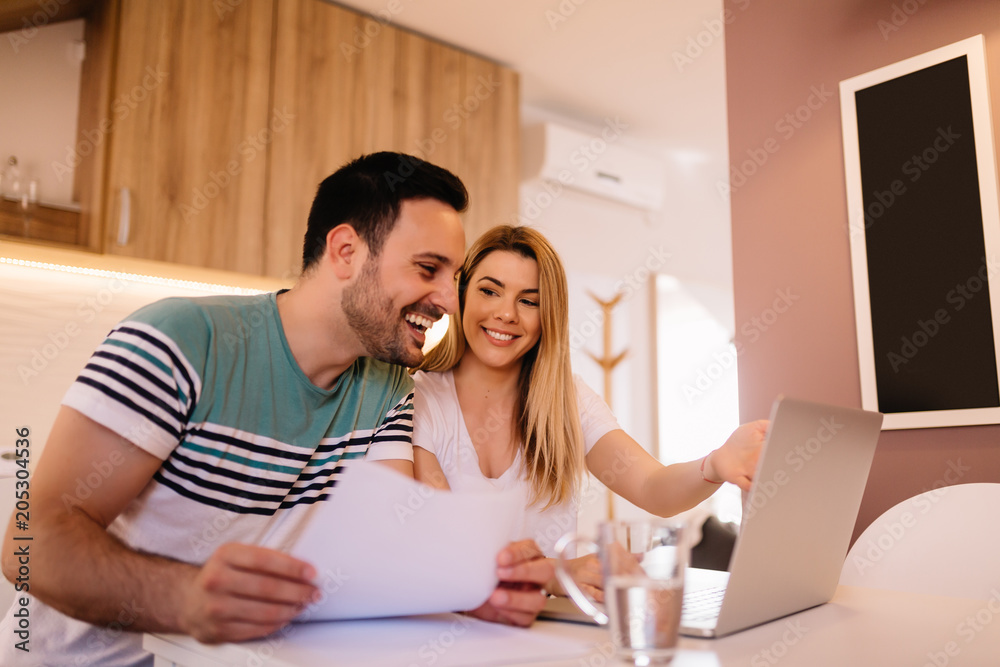 Happy young couple calculating bills at home Happy young couple calculating bills at home