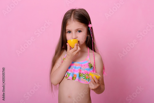 Caucasian beautiful little girl with fresh yellow . Little girl with lemon