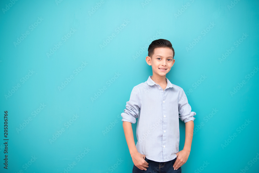 Young boy isolated in blue. Handsome early teenage boy portrait. Happy smile pose. Young boy isolated in blue. Handsome early teenage boy portrait. Happy smile pose.