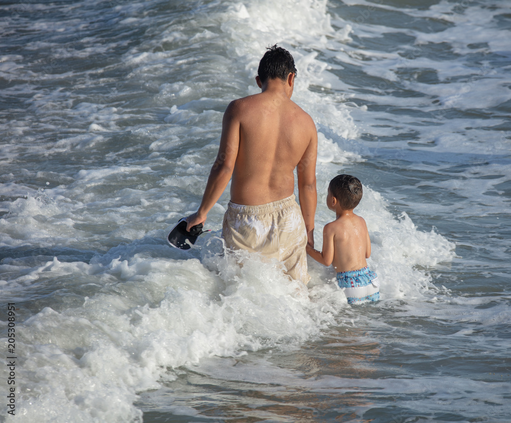Fototapeta premium unknown big brother holds little brothers hand while going through deep waters