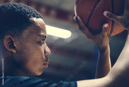 African American teenage boy concentrated on playing basketball © Rawpixel.com