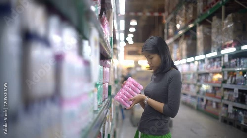 Asian girl is choosing household chemicals in supermarket 4k UHD 3840x2160
 photo