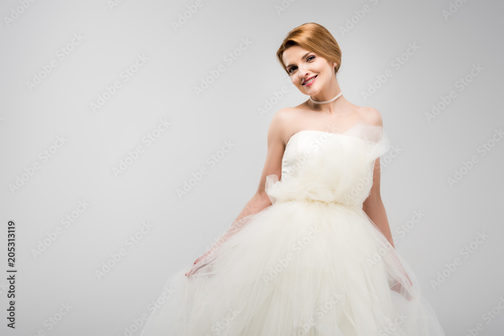 beautiful smiling bride posing in white wedding dress, isolated on grey