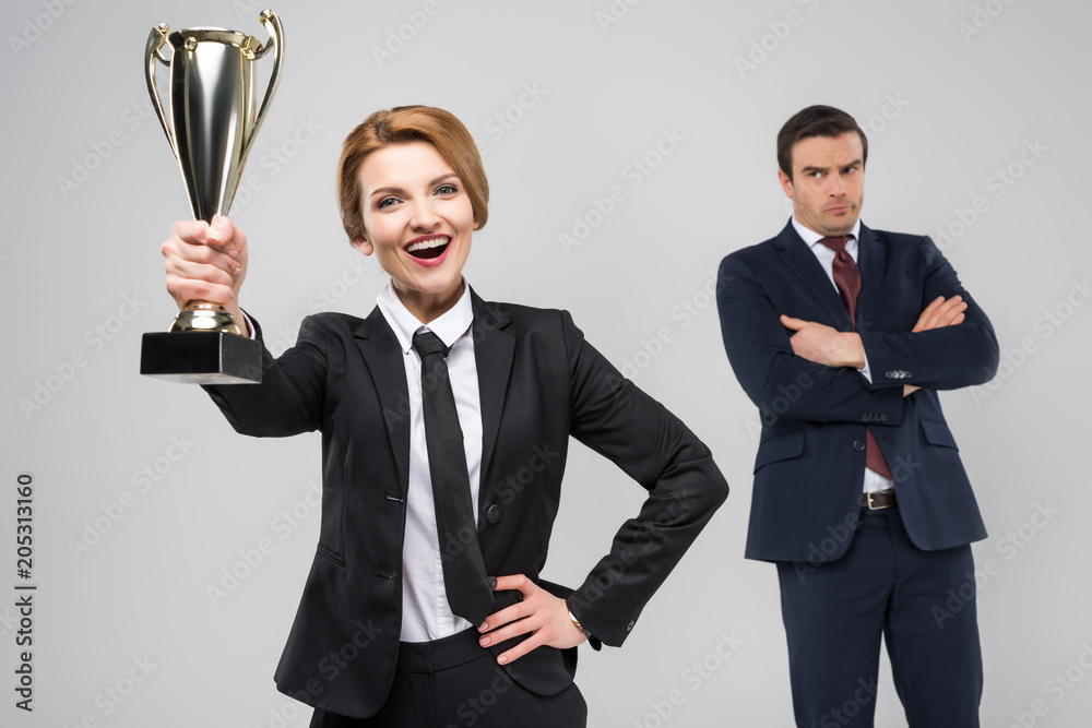 Φωτογραφία excited businesswoman with award and upset businessman behind, isolated on grey