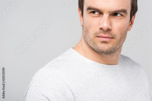 portrait of handsome man looking away, isolated on grey