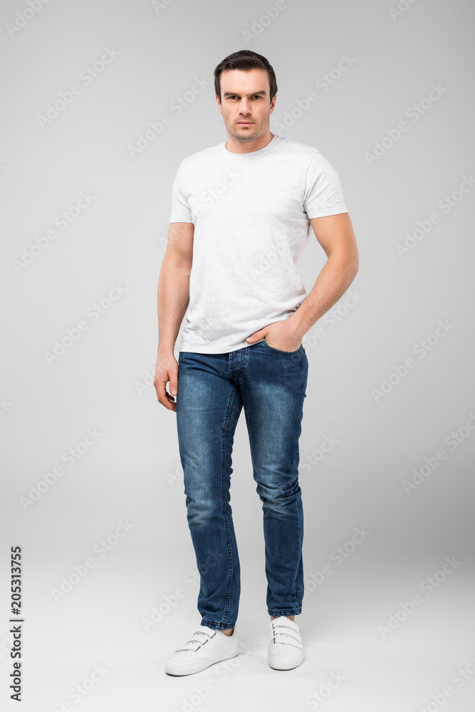handsome man with hand in pocket looking at camera, isolated on grey handsome man with hand in pocket looking at camera, isolated on grey