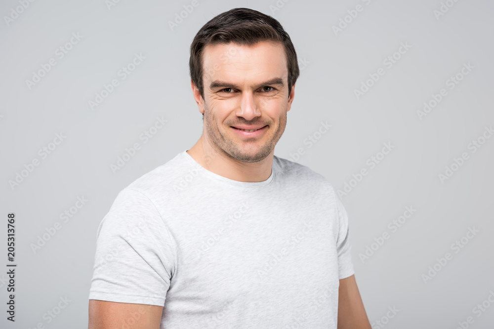 portrait of handsome man smiling at camera, isolated on grey portrait of handsome man smiling at camera, isolated on grey