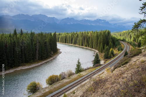 Railway Winding Alongside River in Rocky Mountains