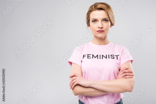 confident woman in pink feminist t-shirt with crossed arms, isolated on grey photo