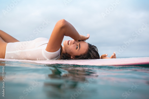 Photography beautiful young woman relaxing on surfboard in ocean during summer vacation