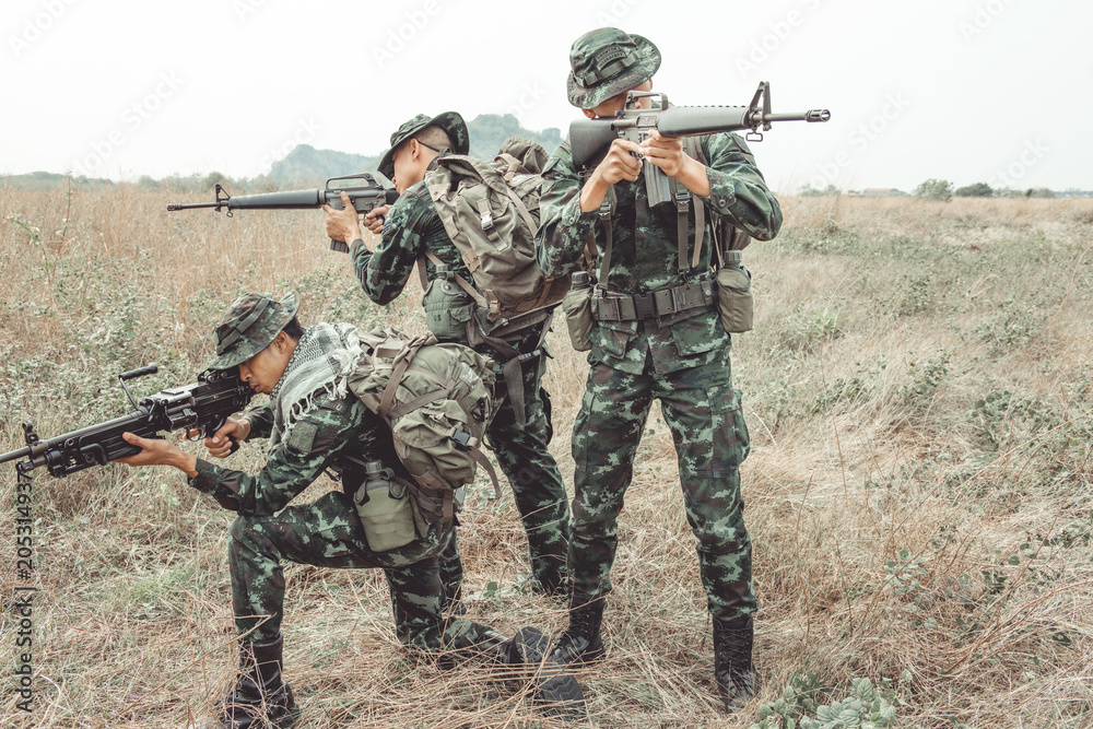 Soldier ready his weapon. Standing and kneeing holding their assault rifle. Portrait full body shot. Digital green camo. Soldier ready his weapon. Standing and kneeing holding their assault rifle. Portrait full body shot. Digital green camo.