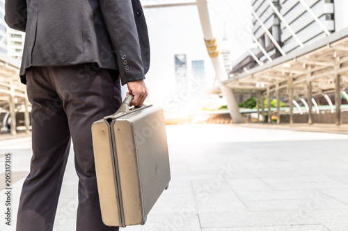 Handsome on the street at metropolis with old briefcase. He is salesman. Attractive businessman goes to meeting some that he gets appointment with copy space, cityscape Stock-foto