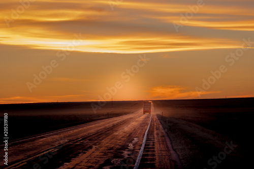 MARCH 8  2017  NEBRASKA - Sunset over Rural Farm Country Road with pickup truck driving by row of powerlines